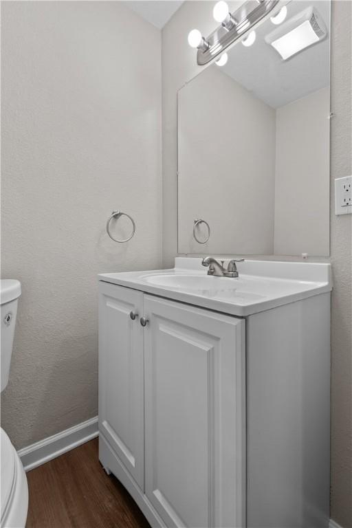 bathroom with vanity, hardwood / wood-style floors, and toilet