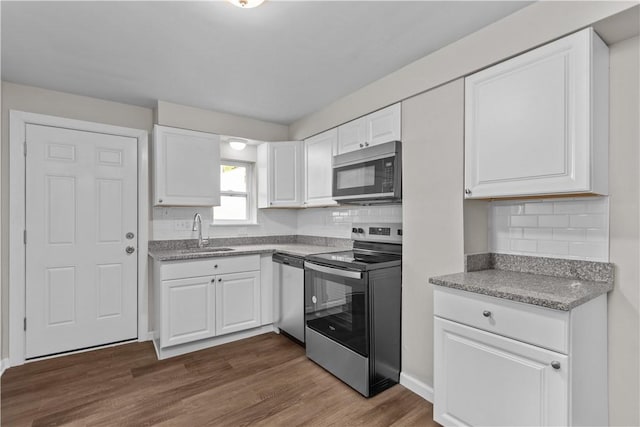 kitchen featuring white cabinetry, appliances with stainless steel finishes, sink, and dark wood-type flooring