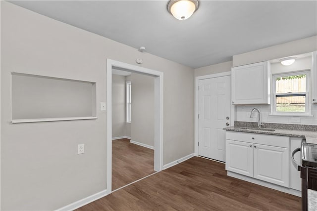 kitchen featuring dark hardwood / wood-style flooring, sink, light stone counters, and white cabinets