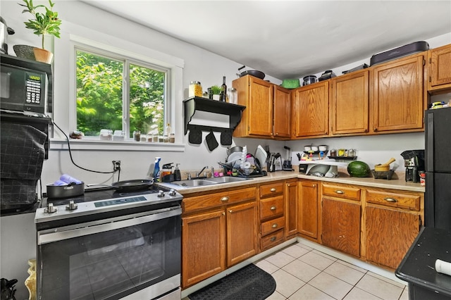 kitchen with sink, black appliances, and light tile floors