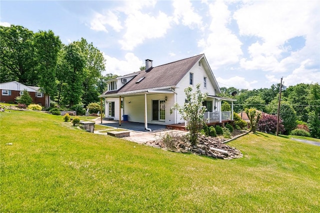 rear view of house with a lawn and a patio area