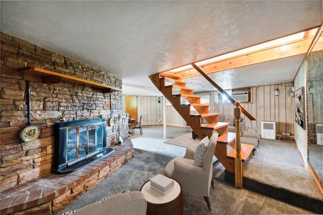 unfurnished living room featuring carpet floors, wooden walls, a wall mounted AC, and a fireplace