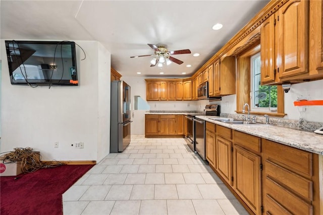 kitchen with ceiling fan, sink, light stone counters, and stainless steel appliances