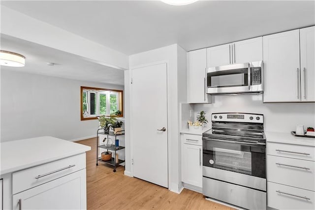 kitchen featuring white cabinets, appliances with stainless steel finishes, and light hardwood / wood-style flooring