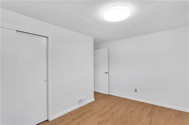 unfurnished bedroom featuring light hardwood / wood-style flooring and a closet