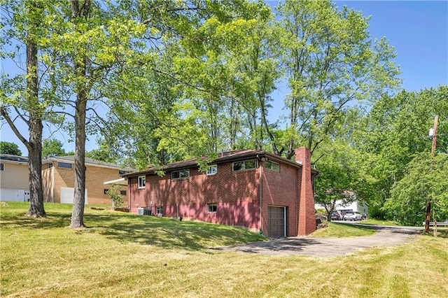 view of side of property with a lawn and a garage