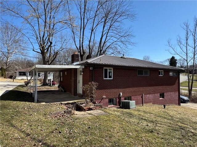 view of home's exterior featuring a lawn, a carport, metal roof, brick siding, and a chimney