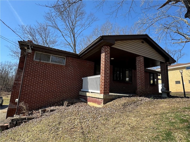 view of home's exterior featuring brick siding and a porch