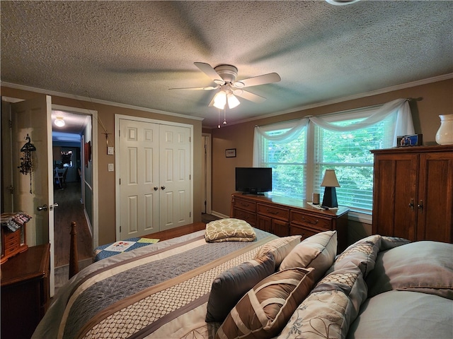 bedroom with ceiling fan, crown molding, a closet, and a textured ceiling