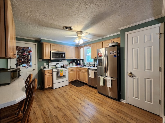 kitchen with appliances with stainless steel finishes, light hardwood / wood-style floors, crown molding, light brown cabinets, and ceiling fan