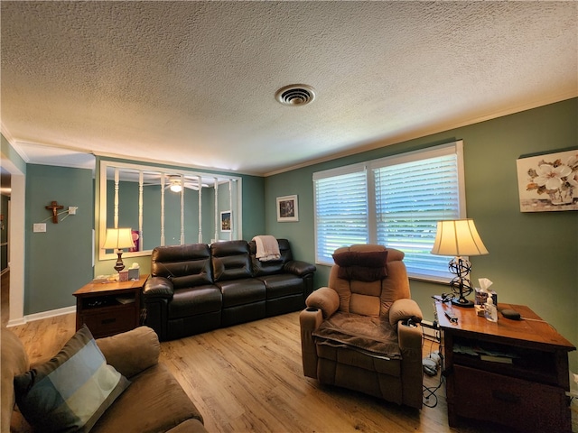 living room with crown molding, light hardwood / wood-style flooring, and a textured ceiling