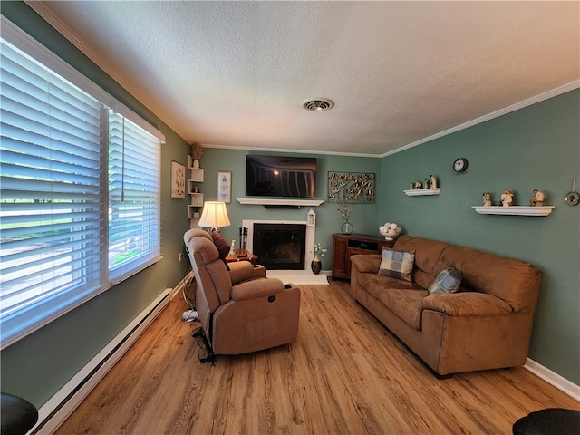 living room featuring a baseboard heating unit, hardwood / wood-style flooring, ornamental molding, and a textured ceiling