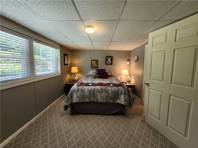 bedroom featuring a drop ceiling and carpet floors