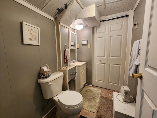 bathroom with a textured ceiling, vanity, and toilet