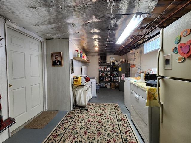 interior space featuring white refrigerator, concrete flooring, and electric water heater