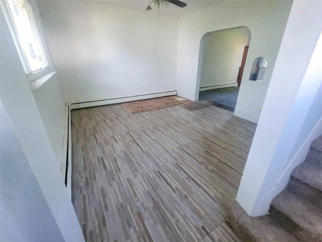 empty room featuring ceiling fan, a baseboard radiator, and hardwood / wood-style flooring