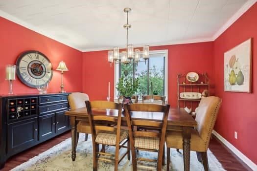 dining area featuring crown molding, a chandelier, and dark hardwood / wood-style floors