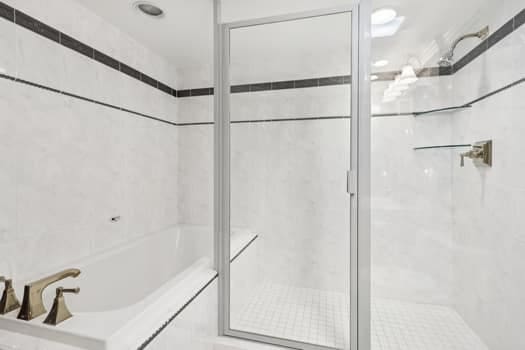 bathroom featuring separate shower and tub