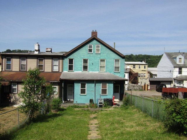 rear view of property featuring a lawn