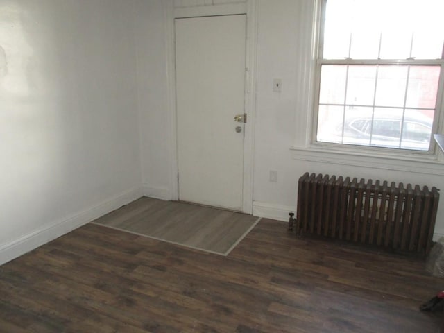 entrance foyer featuring baseboards, dark wood-type flooring, and radiator