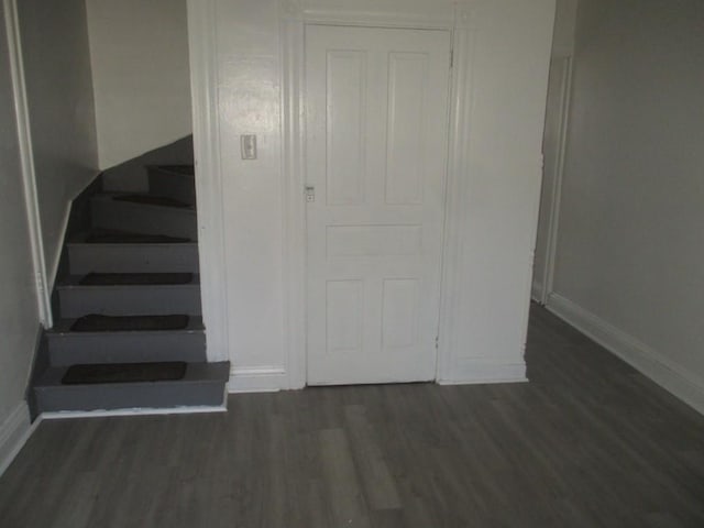 stairs featuring wood finished floors and baseboards