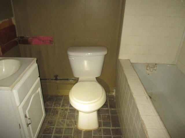 full bathroom with a washtub, vanity, toilet, and tile patterned floors