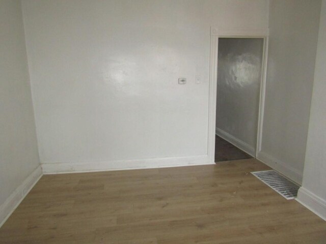 spare room with light wood-type flooring, baseboards, and visible vents