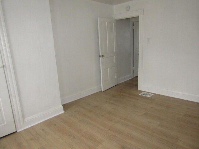 empty room with light wood-type flooring and baseboards