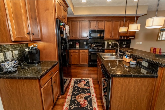 kitchen with black appliances, dark wood-type flooring, backsplash, hanging light fixtures, and sink