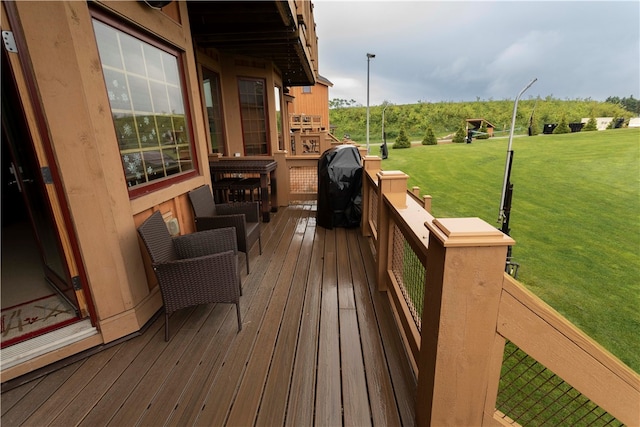 deck featuring area for grilling and a lawn