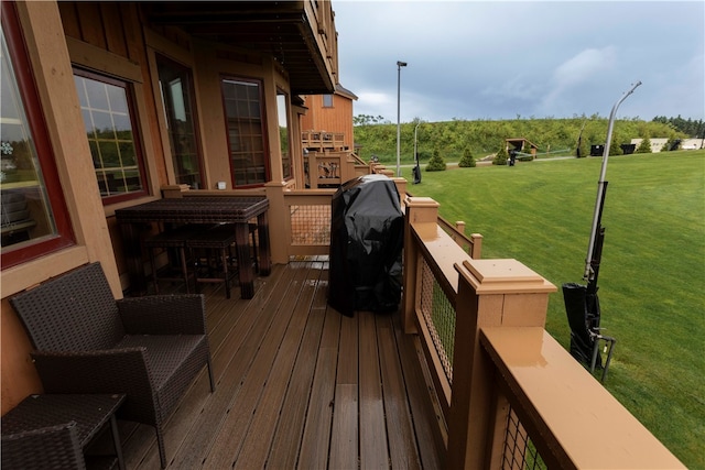 wooden terrace featuring a lawn