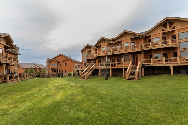 rear view of house with a deck and a yard