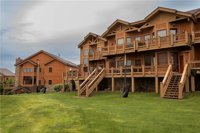 rear view of house with a wooden deck and a yard