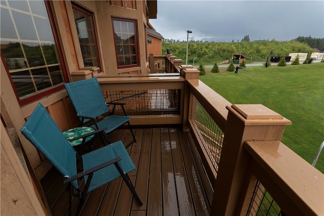 wooden terrace featuring a lawn