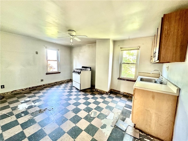 kitchen featuring sink, plenty of natural light, white range with gas cooktop, and ceiling fan