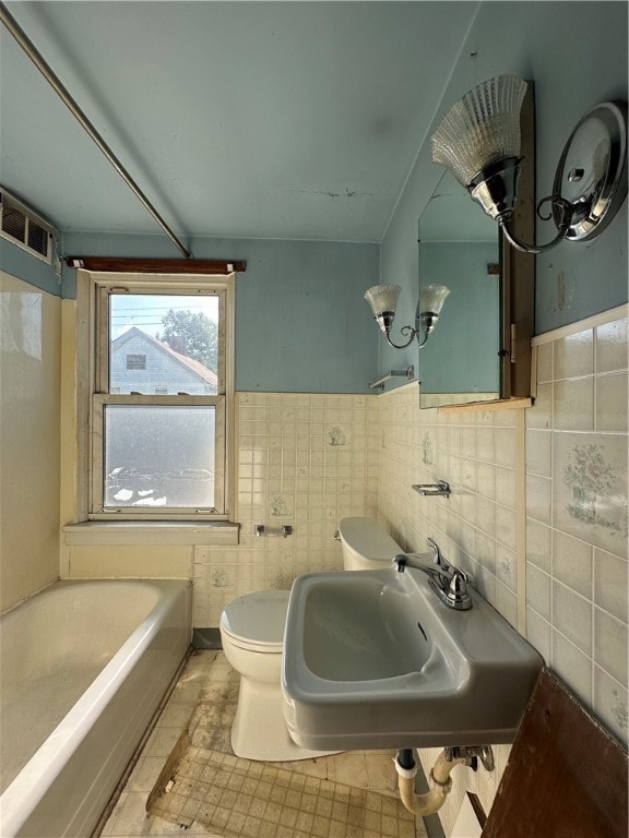 bathroom featuring tile floors, sink, toilet, and tile walls