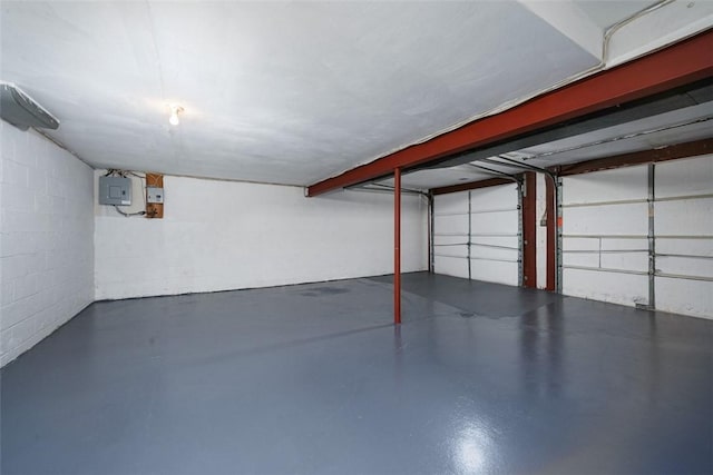 garage with electric panel and concrete block wall