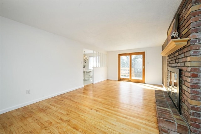 unfurnished living room with baseboards, wood finished floors, and a fireplace