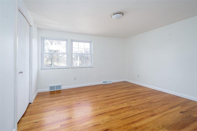 unfurnished bedroom with light wood-style floors, visible vents, a closet, and baseboards