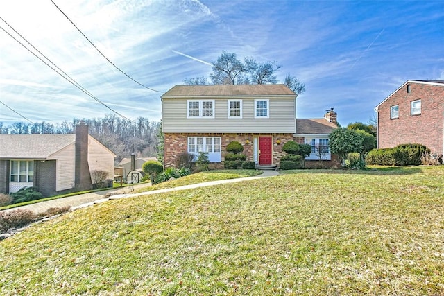 colonial inspired home featuring brick siding and a front lawn