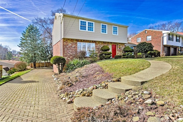 colonial inspired home featuring a front yard and brick siding