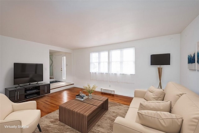 living area with visible vents, baseboards, and wood finished floors