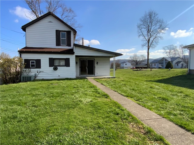 back of house with central AC and a yard