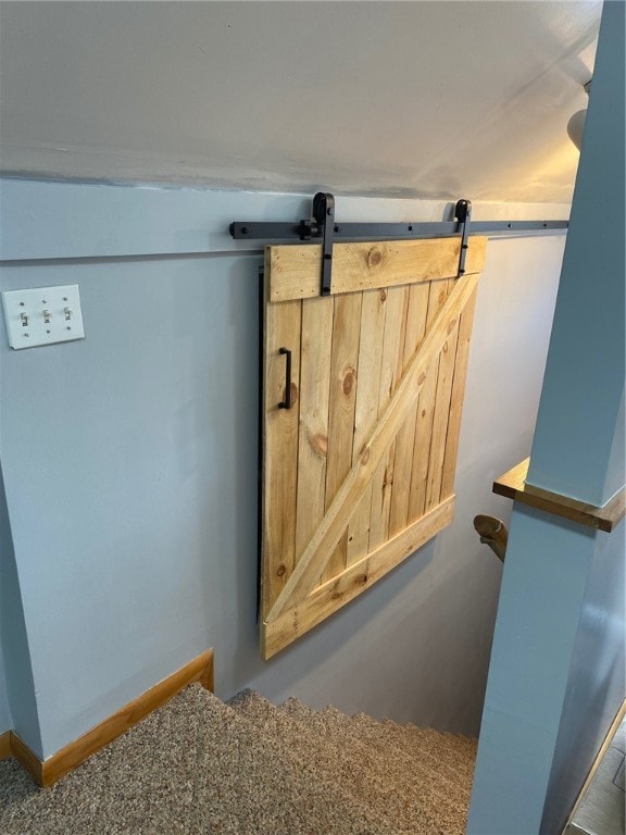 interior details with carpet floors and a barn door