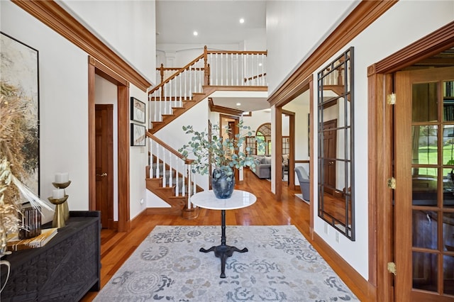 entryway with a towering ceiling, french doors, and wood-type flooring