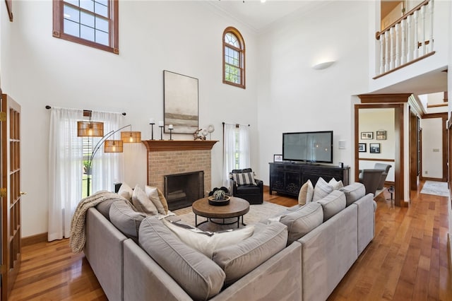 living room with a high ceiling, a fireplace, and wood-type flooring