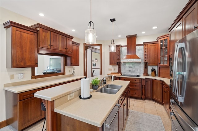 kitchen featuring sink, stainless steel fridge, and a kitchen island with sink