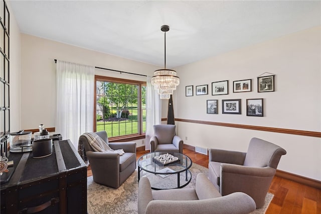 living room with a notable chandelier and wood-type flooring