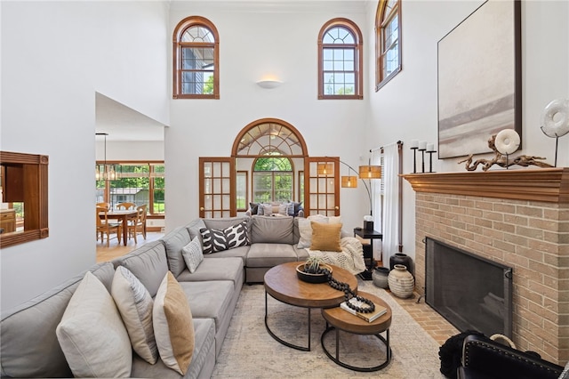 living room with a brick fireplace and a towering ceiling