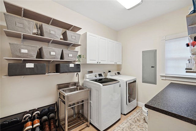 laundry room featuring washer and dryer, cabinets, light hardwood / wood-style flooring, hookup for a washing machine, and electric dryer hookup